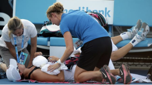 Yaroslava Shvedova of Kazakhstan receives treatment by trainers during her first round match against Sloane Stephens of the U.S. at the Australian Open tennis championship in Melbourne, Australia, Tuesday, Jan. 14, 2014.(AP Photo/Aaron Favila)